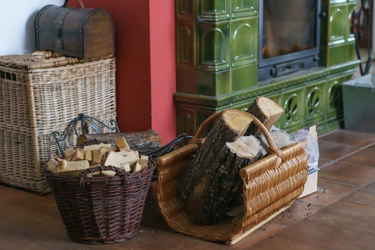 services-img Charming indoor setting with a rustic fireplace, firewood, and woven baskets, evoking warmth and comfort.